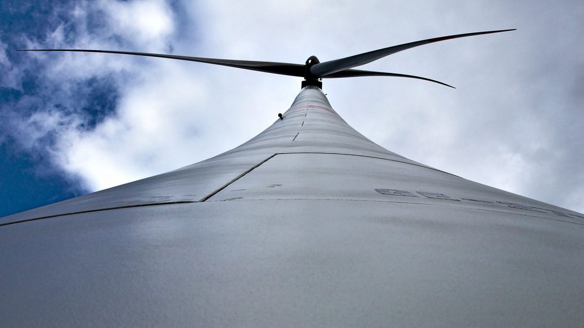 Windkraftanlage von unten mit blauem Himmel
